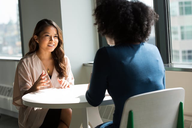 two-people-sitting-at-a-table-having-a-conversation two-people-sitting-at-a-table-having-a-conversation