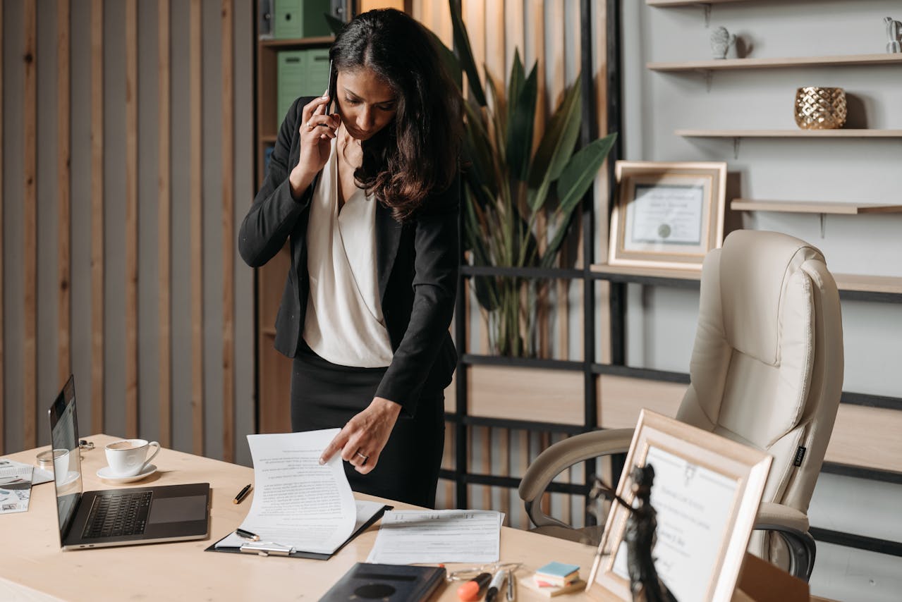 person-talking-on-phone-and-looking-at-papers